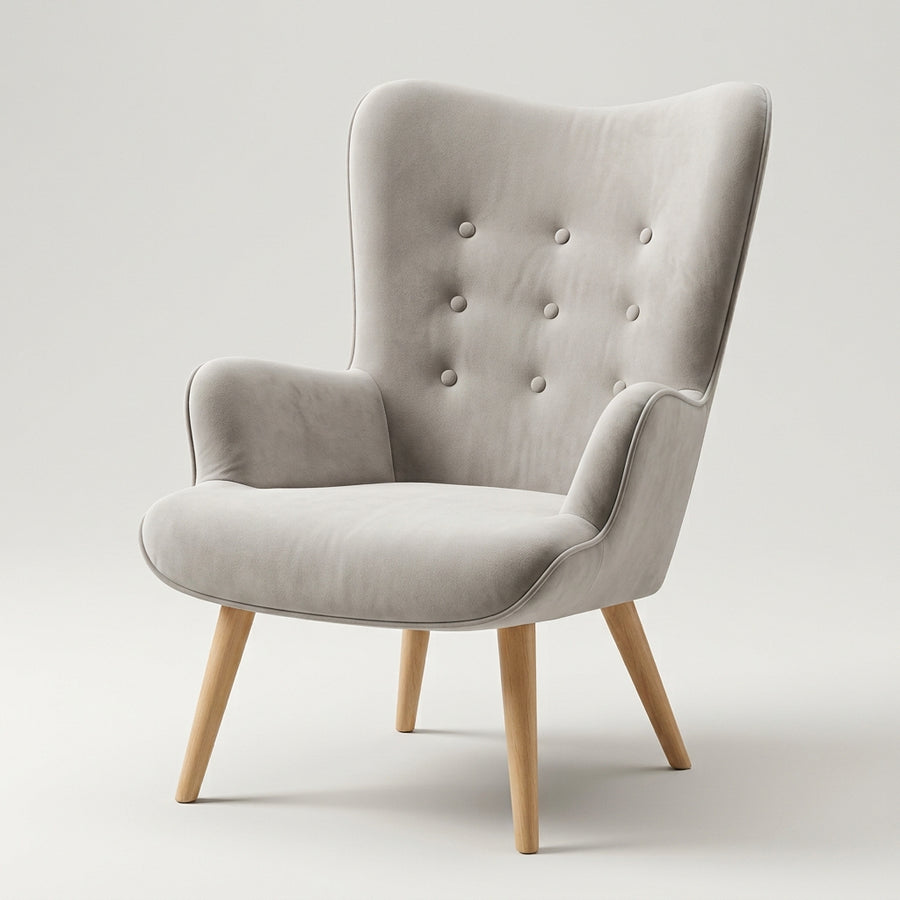 Sillón de lectura Tarina de terciopelo gris con respaldo alto capitoné y patas de madera, vista tres cuartos